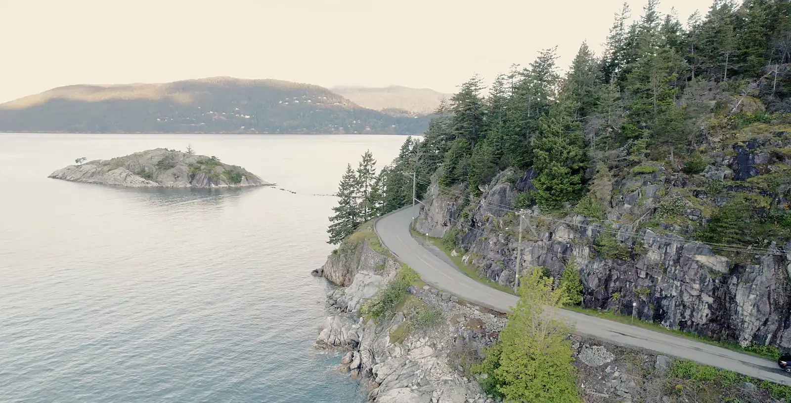 A coast road and a small wooded island seen from above