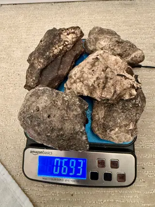 Another mixed pile of ambergris pieces from the sorted lot on a digital scale