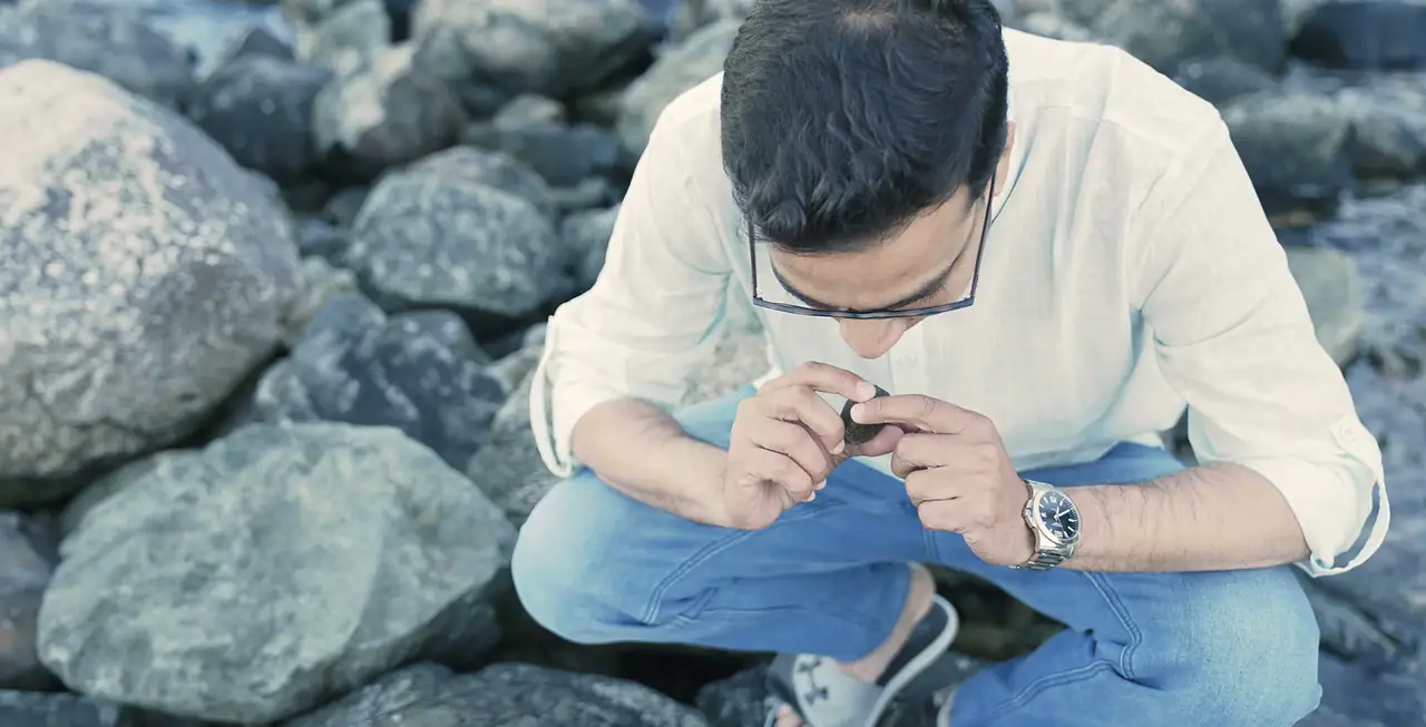 Nabil Valiulla crouched on the shore, studying a piece of ambergris